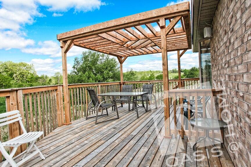 Wooden Pergola on top of wooden deck surrounded by wooden fence