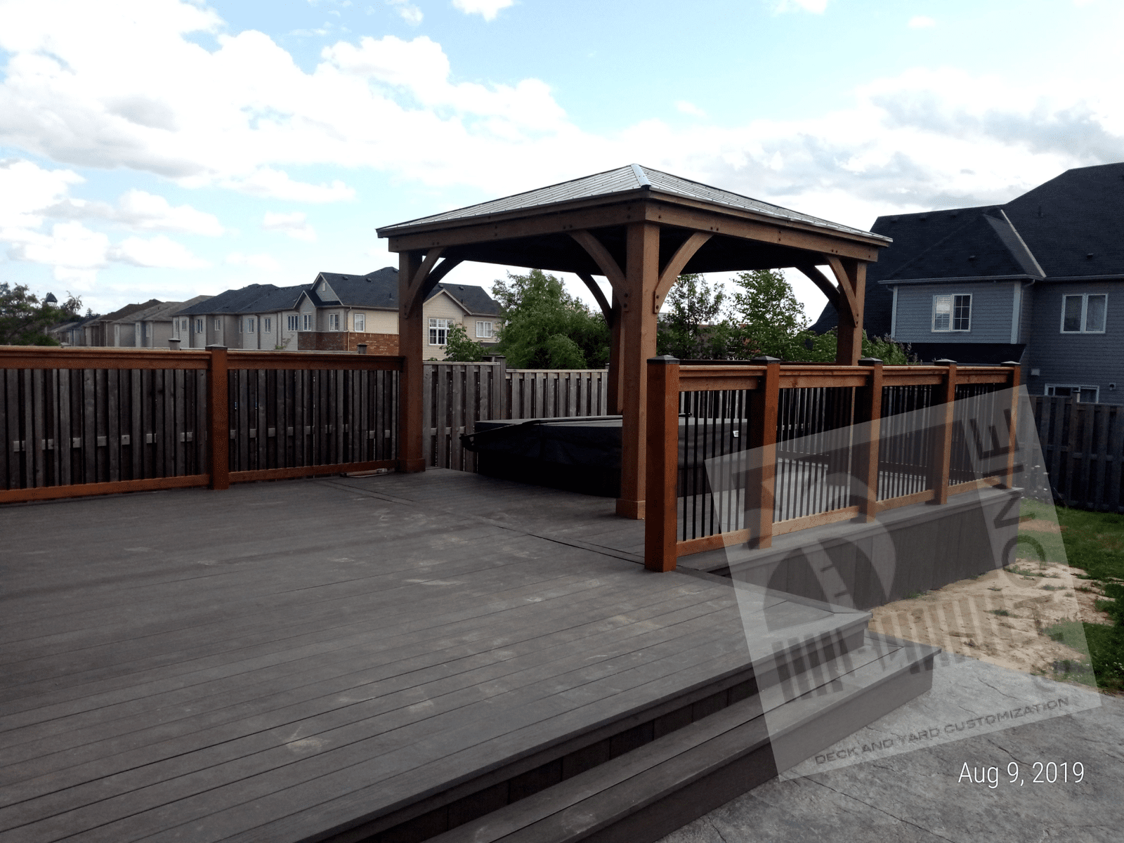 Gazebo on a wooden deck with a wood and metal bar fence